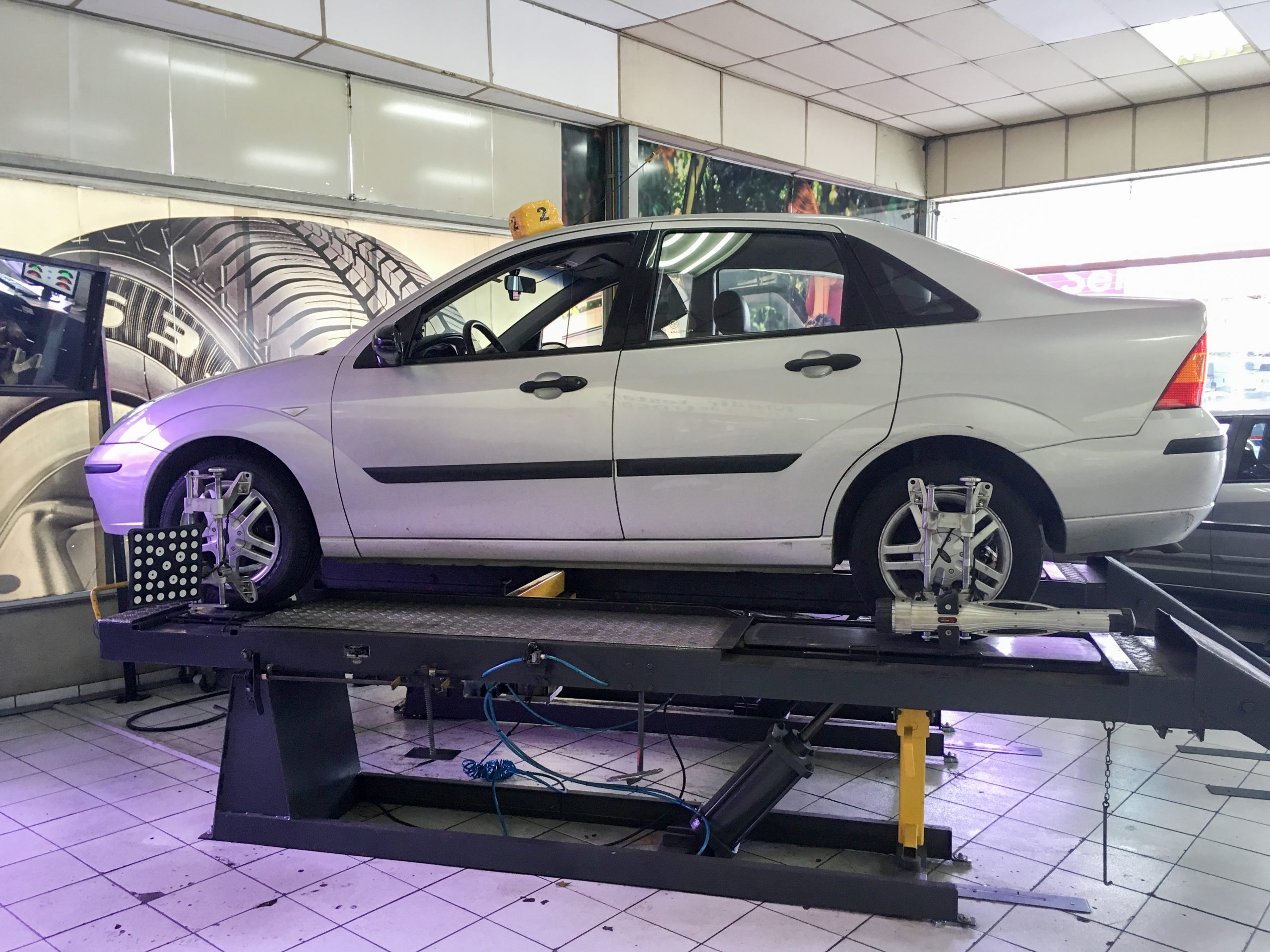 A digital wheel alignment sensor system mounted on a car tire in a professional workshop