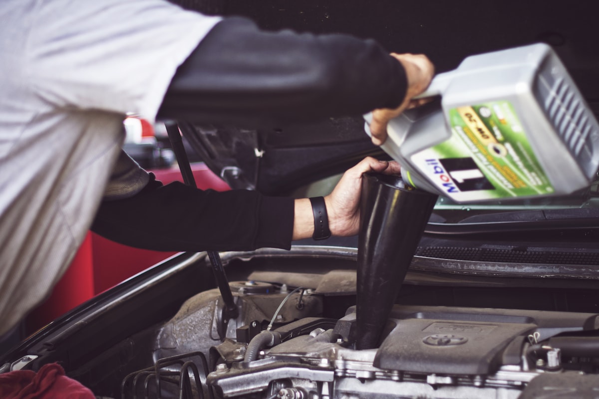 Mechanic servicing car air conditioning system
