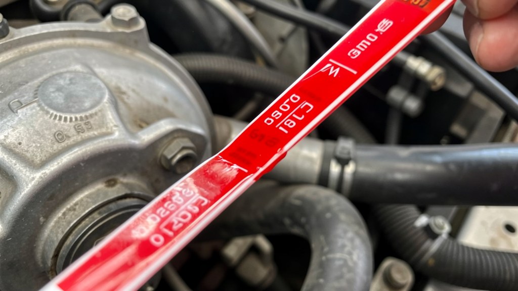 Transmission dipstick showing fluid level and colour comparison